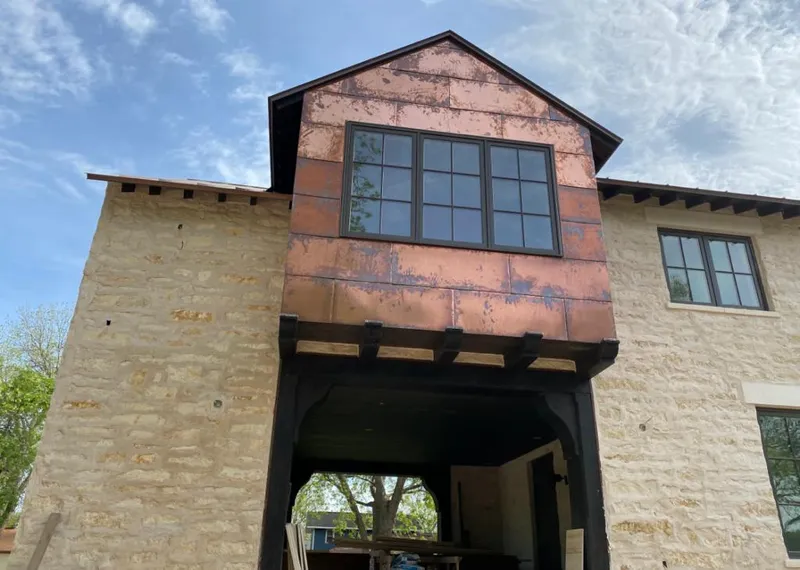 Copper metal panel facade on a stone building for Roof Repair in Lamar